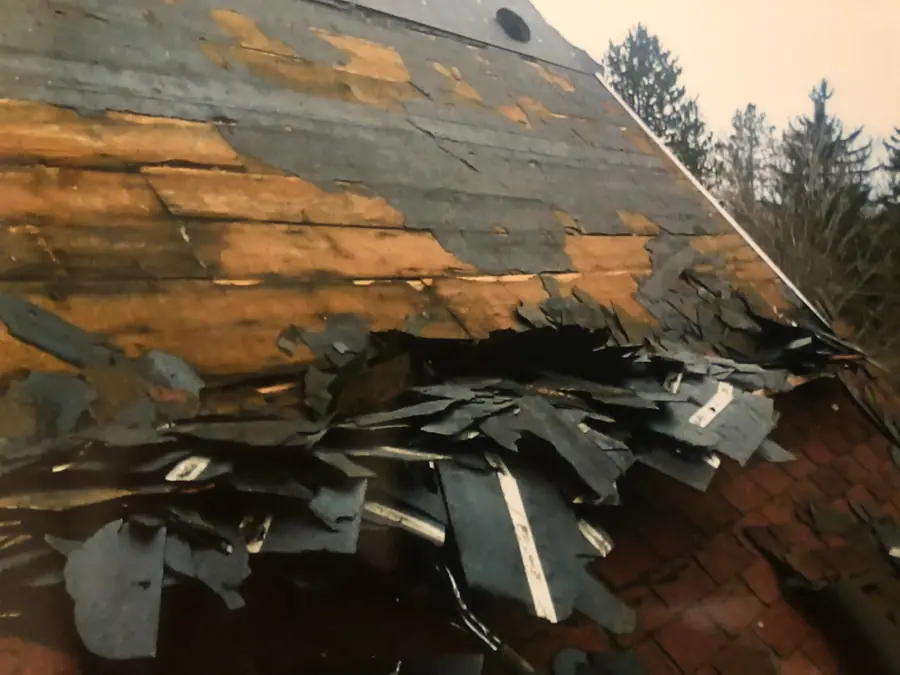 Old shingles being torn off a roof down to the wood deck